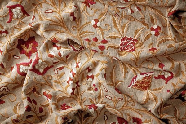 Red fabric, trailing flowers and leaves on a warm, natural linen background.